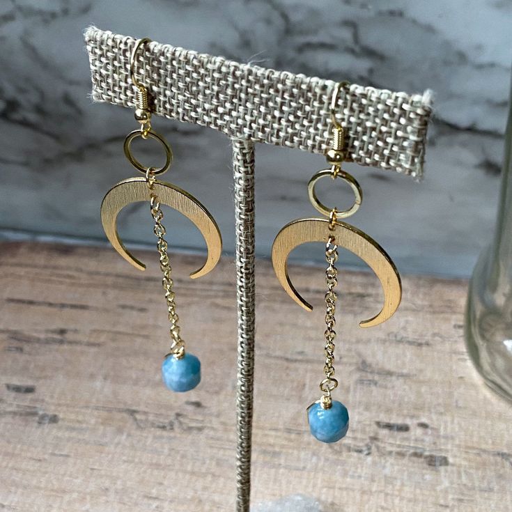 "These handmade earrings features tiny gold or silver circles and crescent moons, both made from gold/silver plated raw brass, with a dangly gold chain and Aquamarine energy prism beads. They are about just over 3\" long when worn. Aquamarine is a member of the Beryl family, known for its stunningly clear greenish-blue color that resembles a Carribean sea. Darker varieties are the rarest. It is associated with the Third Eye and Throat chakras, along with the planets Venus and Neptune, the \"D\" Gold Half Moon Shaped Metal Jewelry, Brass Moon Charm Jewelry, Nickel-free Adjustable Moon-shaped Jewelry, Nickel-free Adjustable Moon Shaped Jewelry, Mystical Gold Moon Phase Earrings, Elegant Brass Earrings With Moon Charm, Dainty Metal Jewelry With Moon Charm, Adjustable Crescent Brass Jewelry, Minimalist Half Moon Metal Jewelry