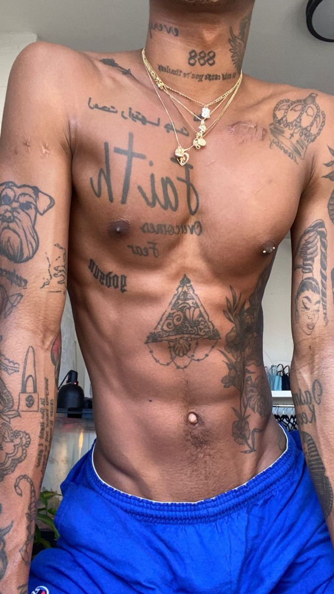 a shirtless man with tattoos on his chest and arms is posing for the camera