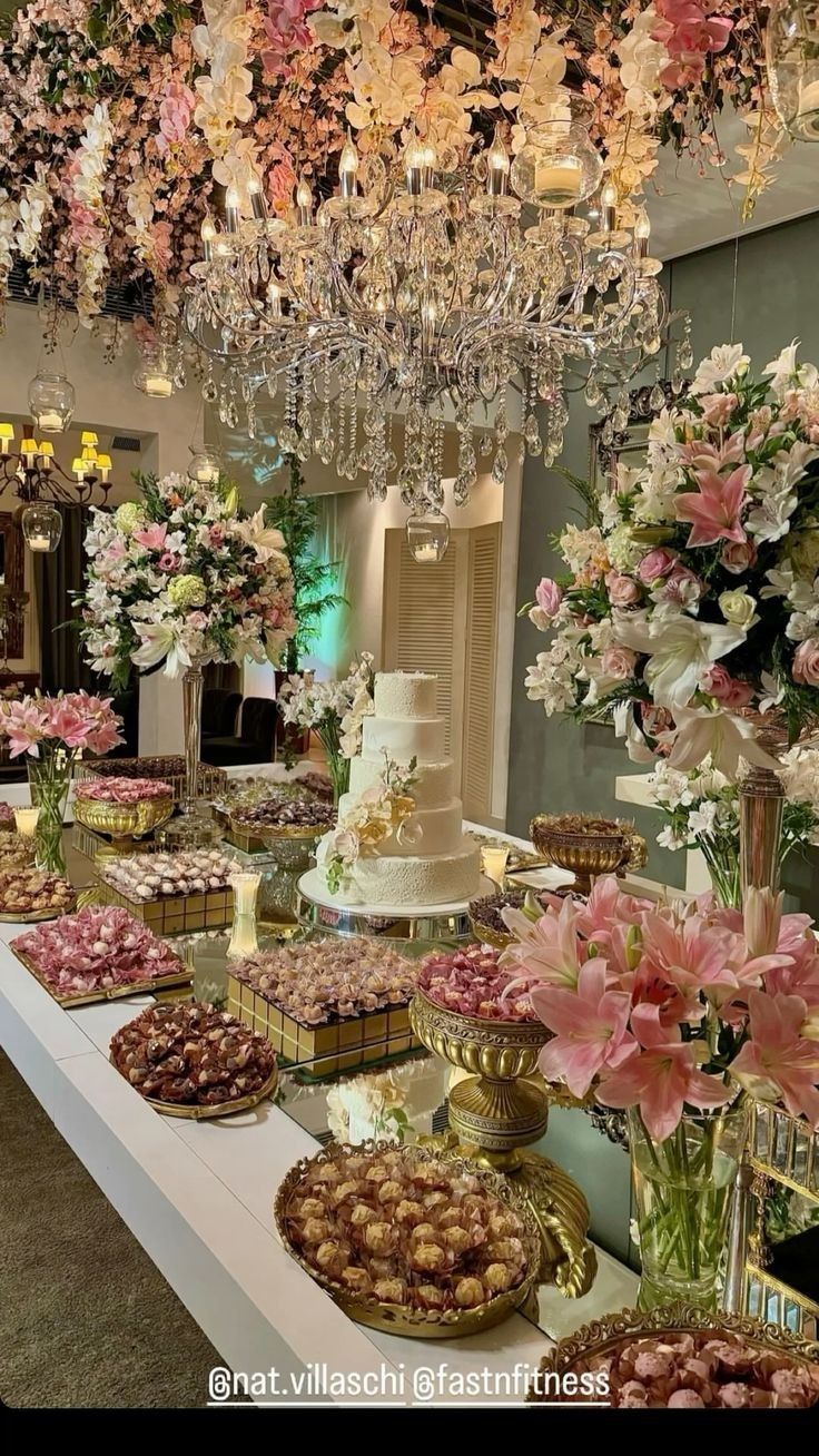 a table topped with lots of cakes and flowers