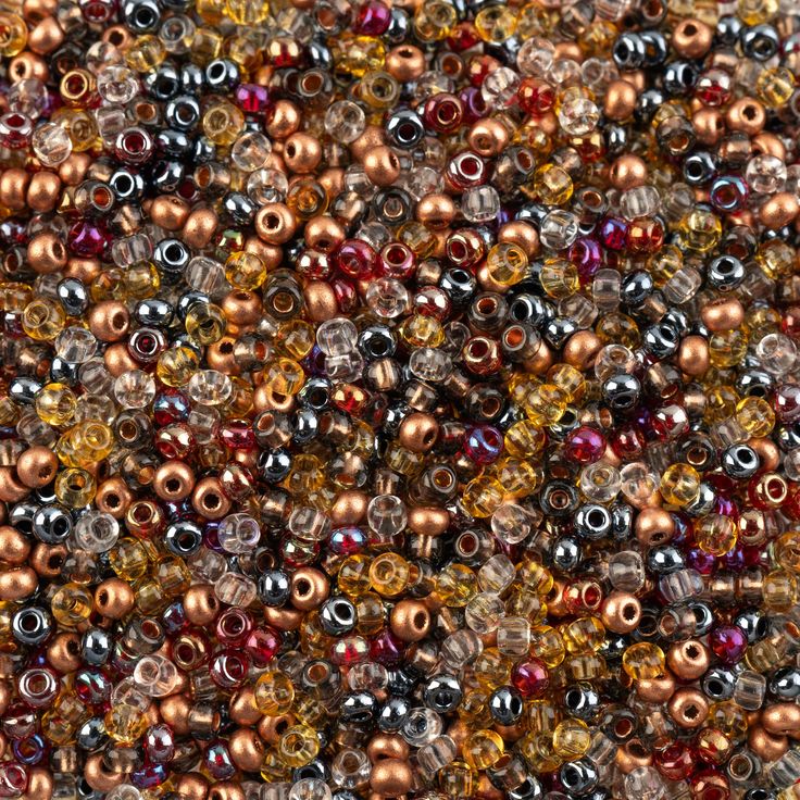 many different colors of beads are shown in this close up photo, including golds and browns