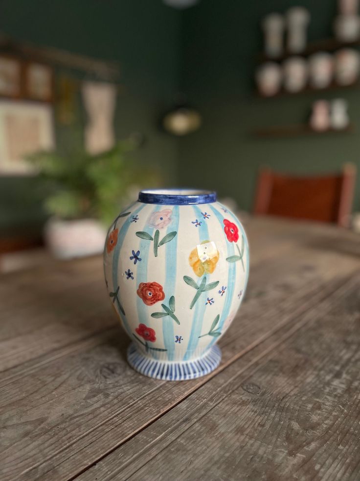 a blue and white vase sitting on top of a wooden table