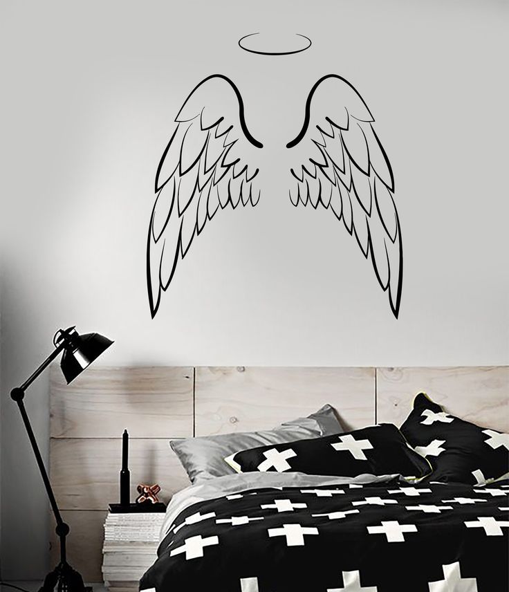 an angel wings wall decal above a bed in a bedroom with black and white decor