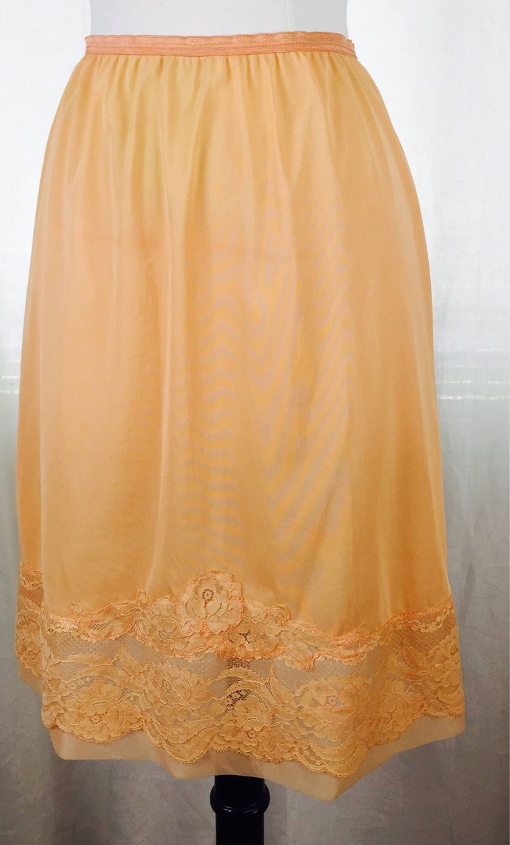 Vintage 50's over dyed mango orange colored slip skirt with lace trim and sheer inserts. Fabric is a soft silky rayon blend. Perfect as a summer skirt with sandals and a tank. Fits modern ladies' sizes 4-6 best.  22" total length 11 " flat waist stretches comfortably up to 15" flat waist  16" flat hip 21" flat hemline Summer Bottoms With Contrast Lace And Stretch, Summer Bottoms With Stretch And Contrast Lace, Stretch Bottoms With Contrast Lace For Summer, Stretch Summer Bottoms With Delicate Lace, Summer Skirt With Lace Trim And Stretch, Stretch Skirt With Lace Trim For Summer, Stretch Lace Skirt For Summer, Fitted Lace Trim Skirt For Summer, Vintage Style Stretch Bottoms With Lace Trim