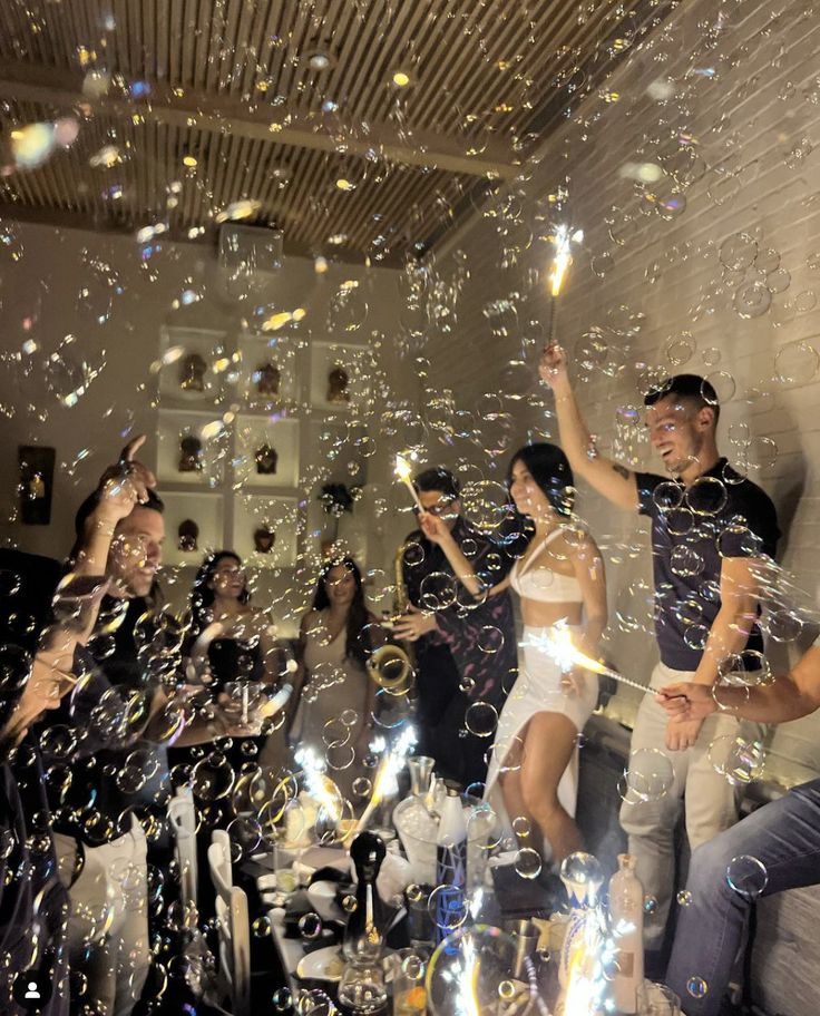 a group of people standing next to each other on top of a floor covered in bubbles