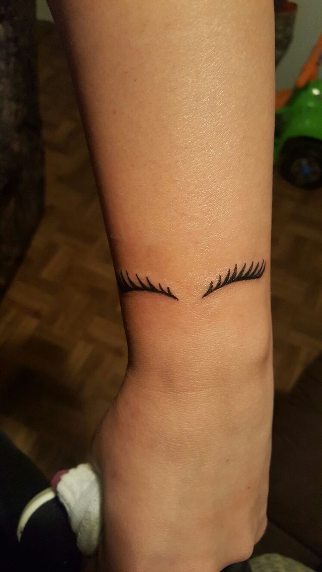 a woman's foot with eyelashes tattoo on her left side calf and the bottom part of her leg