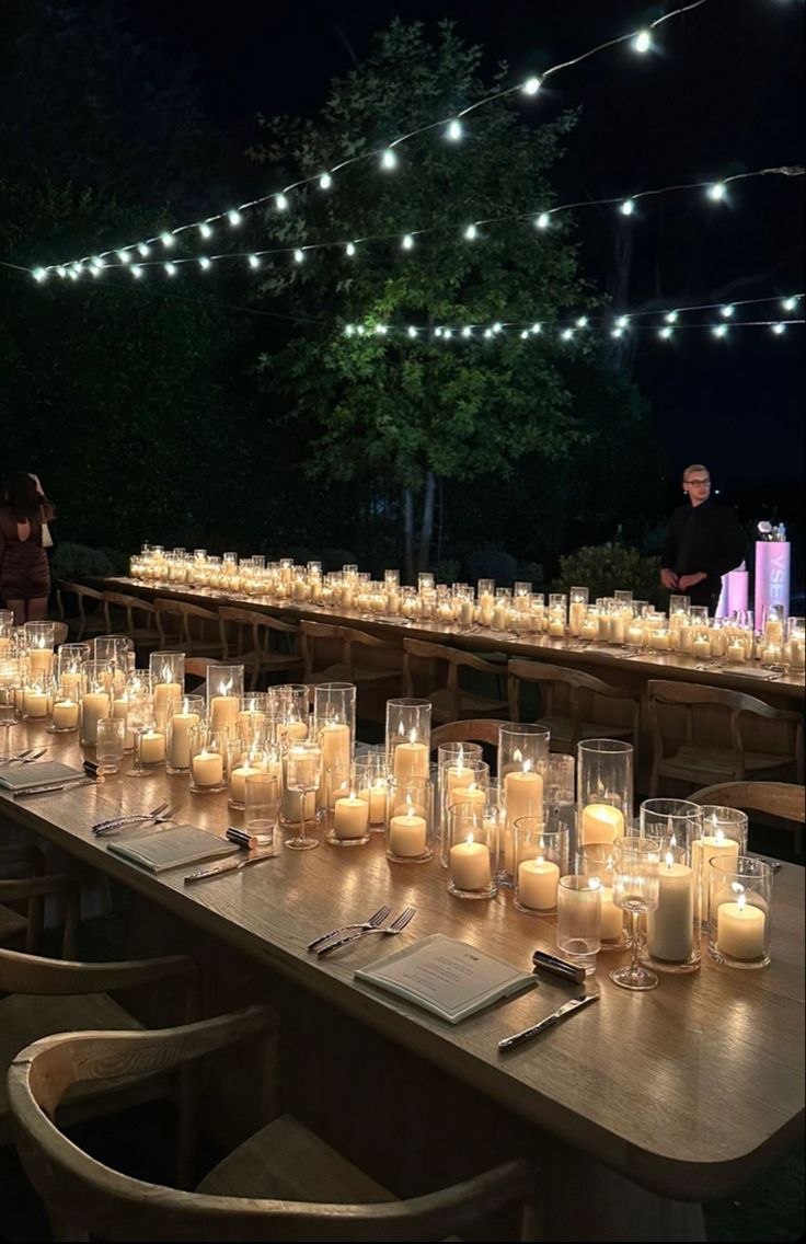 a long table with many lit candles on it