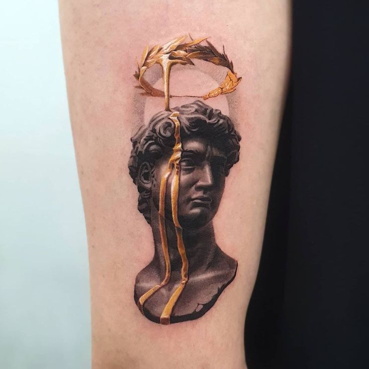 a woman's leg with a gold ribbon wrapped around it and an image of a bust