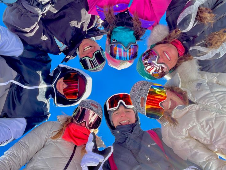 a group of people standing in a circle wearing ski goggles