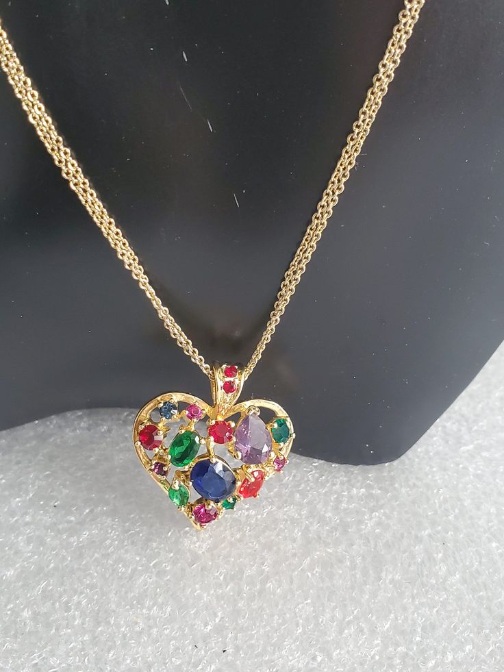 "If you are searching for the perfect Valentine's Day gift than you come to the right place. Presented here is a multi-colored glass heart pendant necklace that is strung onto a double curb chain. Both pieces are made in a gold tone base metal with no hallmark. The heart pendant has an open back where you can see the colored stones. The bale also has 2 small red stones and is big enough for any type of chain. Both pieces are vintage and are in excellent condition and will arrive in a gift box wi Multicolor Party Necklaces For Valentine's Day, Multicolor Heart Cut Jewelry For Valentine's Day, Multicolor Jewelry For Valentine's Day Party, Multicolor Heart Charm Necklace For Party, Multicolor Heart Pendant Jewelry For Parties, Valentine's Day Party Multicolor Jewelry, Multicolor Jewelry Valentine's Day Gift, Multicolor Jewelry For Valentine's Day Gift, Valentine's Day Multicolor Pendant Jewelry