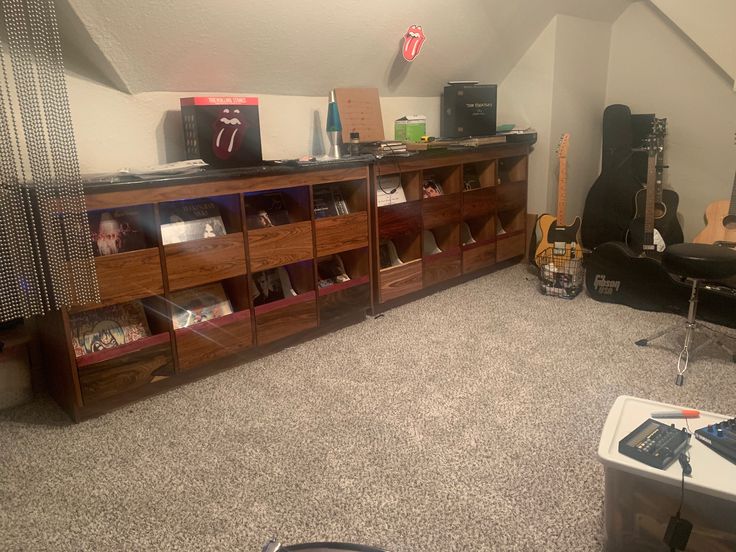 a living room filled with lots of furniture and musical equipment on top of carpeted flooring