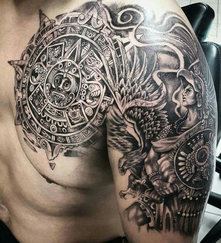 a man's chest with an intricate tattoo design on his arm and shoulder,