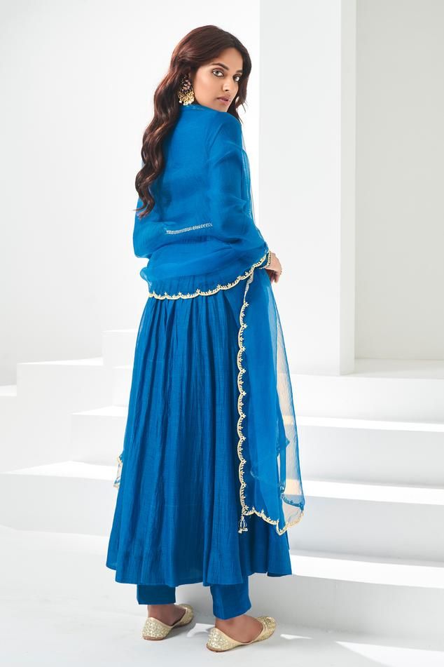 Blue pleated flare anarkali, highlighted with placement pita and kasab work. Paired with a pant and scallop trimmed dupatta.
Components: 3
Pattern: Placement Embroidery
Type Of Work: Pita, Kasab
Neckline: V Neck
Sleeve Type: Full Sleeves
Fabric: Soft Chanderi, Lining: Chanderi
Color: Blue
Other Details: 
Attached inner lining
Length:
Anarkali: 52 inches
Sleeves: 23 inches
Pant: 38 inches
Dupatta: 2.5 mtrs
Occasion: Mehendi and Haldi - Aza Fashions Blue Georgette Sharara With Gota Work, Blue Floor-length Palazzo Set For Reception, Royal Blue Anarkali Set For Diwali, Blue Georgette Anarkali Set With Traditional Drape, Blue Slub Silk Dupatta With Gota Work, Blue Slub Silk Traditional Wear With Sheer Dupatta, Blue Traditional Wear With Sheer Dupatta In Slub Silk, Royal Blue Anarkali Set With Pallu, Bollywood Style Blue Floor-length Palazzo Set