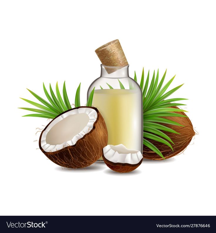 coconut oil in a glass bottle and half an open coconut with green leaves on white background