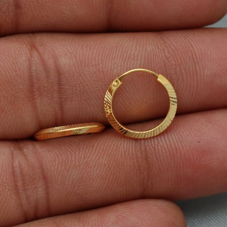 20kt 20 karat small hoop cartilage yellow gold Hoop Bali earrings  Gold Purity- 20k yellow Gold Weight - 0.98 grams approx Full Length - 1.3 cm approx Full Width - 1.3 cm approx click to see similar  https://www.etsy.com/in-en/shop/morvijewels?ref=seller-platform-mcnav Click here  https://morvijewels.etsy.com/    to get more discount and offers Happy to take wholesale bulk orders. Gold-plated Round Cartilage Earrings, Gold Hallmarked Huggie Earrings For Gifts, Elegant Hoop Nose Rings Gift, Hoop Nose Rings For Anniversary, Hallmarked Gold Huggie Earrings For Gift, Gold Dainty Hoop Earrings For Gift, Dainty Gold Hoop Earrings For Gift, Minimalist Diamond Cut Hoop Earrings Gift, Gold-plated Hoop Cartilage Earrings