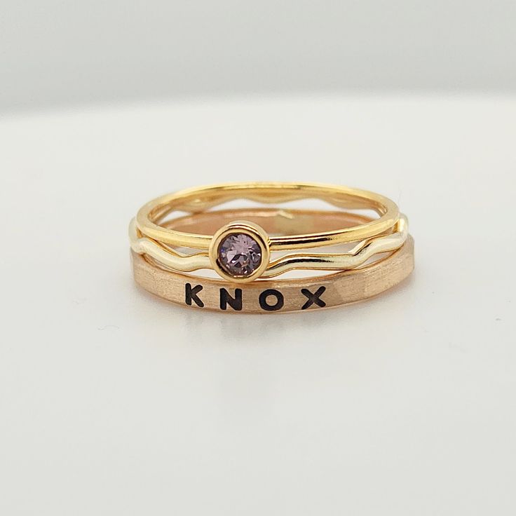 Stackable rings, Engraved Kids Name Rings, 14k yellow gold filled ring set, birthstone rings, Personalized jewelry, Mom Rings, the Alice set Feel the joy of wearing something truly unique with this personalized Name Ring Birthstone Set! Crafted from 14K yellow gold-filled wire, this set includes a bold font name ring, a 1mm wavy ring, and a 4mm bezel birthstone ring.  This set is sure to sparkle and show off your one-of-a-kind personality. Make it an unforgettable gift for the special person in your life! This set is only available in 14K yellow gold filled.  Please note, there may be color variations in the personalized ring and the stacking rings, as this set is handmade. Sizes available: 5, 5.5, 6, 6.5, 7, 7.5, 8, 8.5, 9 *Please note that the size 9 birthstone ring will have a hammered Personalized Engraved 14k Gold Ring, Personalized Engraved Rose Gold Ring, Personalized Rose Gold Birthstone Ring, Personalized 14k Gold Initial Ring, Gold Engraved Stackable Heirloom Rings, Personalized Yellow Gold Stackable Rings, Adjustable Personalized Gold Stackable Rings, Adjustable Yellow Gold Initial Ring With Birthstone, Adjustable Initial Ring In Yellow Gold With Birthstone