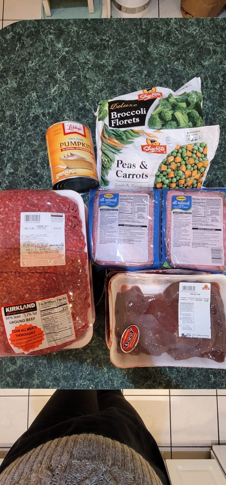 meat and vegetables are laid out on the counter for preparation to be put into freezers