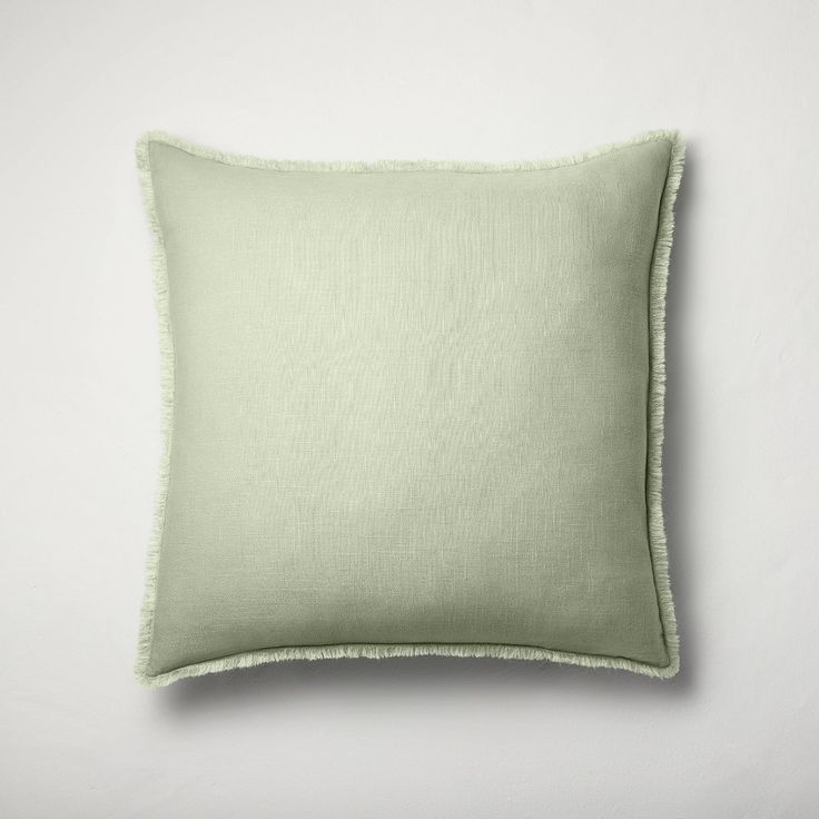 a light green pillow on a white wall