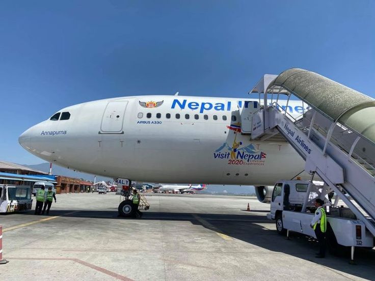 an airplane is parked on the tarmac with people loading it up and onto the plane