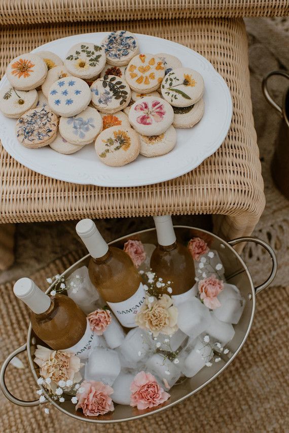 two trays filled with cookies and wine bottles