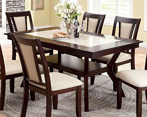 a dining room table with chairs and a rug on the floor