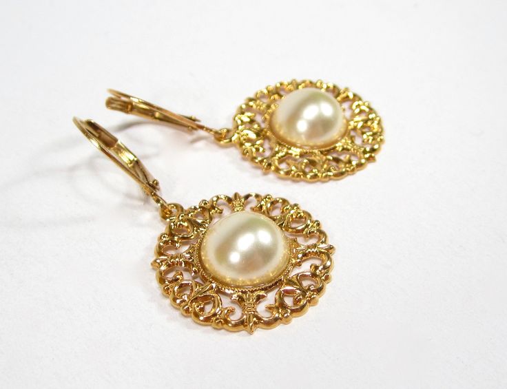 Vintage pearl gold earrings filigree earrings with handmade glass stones from the 1960s gold-plated handmade in Germany The earrings shown are handmade in our studio. The flower consists of tombac, real gold-plated. In the middle we put hand-made glass stones from the 1960s. Color: gold, white The flowers have a diameter of approx. 20 mm. Brand: SoHo® For this ear jewelry we use only materials from Germany. All steps are carried out under fair conditions in Germany lovingly by hand. The frames a Vintage Gold Bridal Earrings, Pierced, Vintage Gold Bridal Earrings, Vintage Style Gold Bridal Earrings For Formal Occasions, Vintage Gold Pearl Earrings As Gift, Vintage Gold Pearl Earrings For Gift, Vintage Gold Bridal Earrings Gift, Handmade Gold Earrings For Evening, Gold Vintage Style Bridal Earrings As Gift, Vintage Gold Filigree Clip-on Earrings