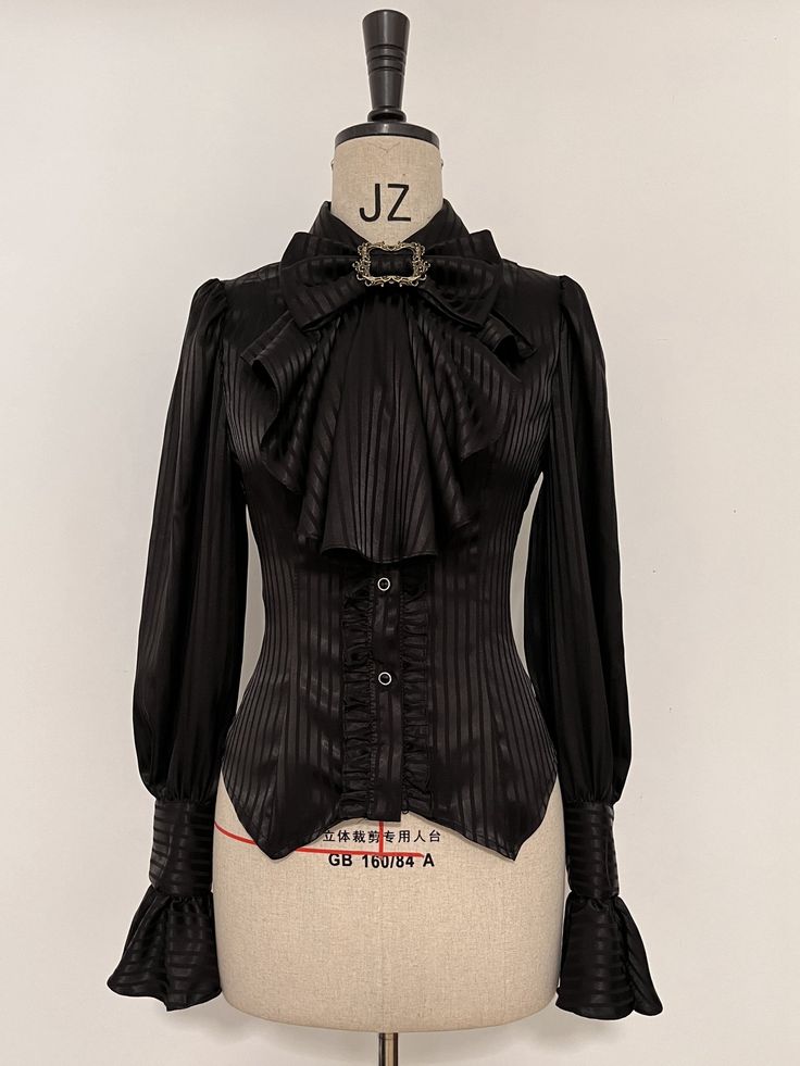 Add a touch of elegance to your Lolita wardrobe with this Black Ouji Long Sleeves Shirt. Featuring a charming jabot bowtie and intricate lace-up detailing at the back, this shirt is the perfect combination of classic and contemporary style. Whether you're attending a tea party or a casual outing, this shirt is sure to make a statement.   	 		 			Size 			S 			M 			L 			XL 			2XL 		 		 			Bust 			86 			90 			94 			98 			102 		 		 			Waist 			68 			72 			76 			80 			84 		 		 			Shoulders 			34 			3 Fitted Party Blouse With Bow Tie, Fitted Bow Tie Blouse For Party, Formal Fitted Blouse With Ruffled Collar, Fitted Elegant Blouse With Bow, Elegant Fitted Blouse With Bow, Feminine Fitted Blouse With Bow, Fitted Feminine Blouse With Bow, Fitted Tie Neck Blouse With Ruffles, Fitted Ruffle Blouse With Tie Neck