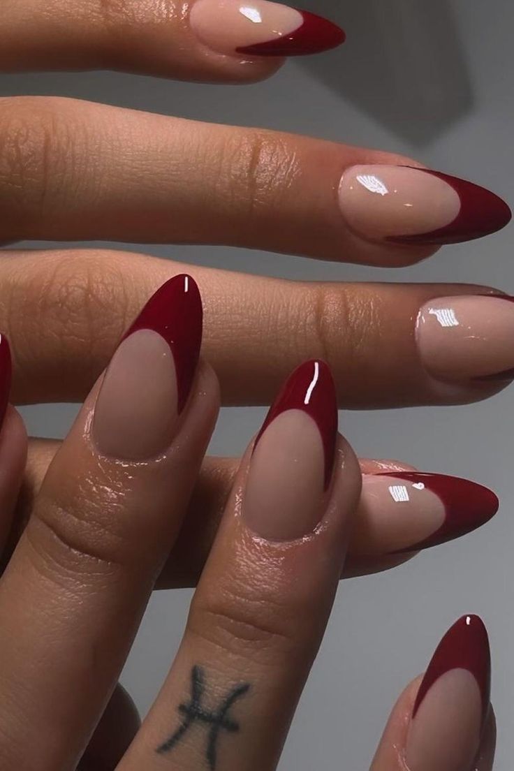 These almond-shaped nails offer a classic French manicure twist with a deep burgundy tip that adds a touch of sophistication. The natural nail base enhances the design, focusing attention on the bold color contrast. Perfect for those looking to combine timeless elegance with a splash of modern flair. ✨  // Photo Credit: Instagram @polishedbyykim Nail Almond Shape French Tip, French Nails Acrylic Almond Shape, Dark Red Nails Tips, Nail Design Almond Shape Classy, Dark Red French Tips Almond, Almond Wine Red Nails, Almond Nails Burgundy French Tip, Bold French Tip Nails, Red Nails French Tip Almond