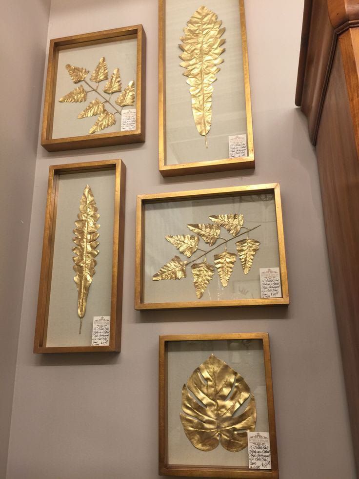 four framed pictures with gold leaf designs on the wall