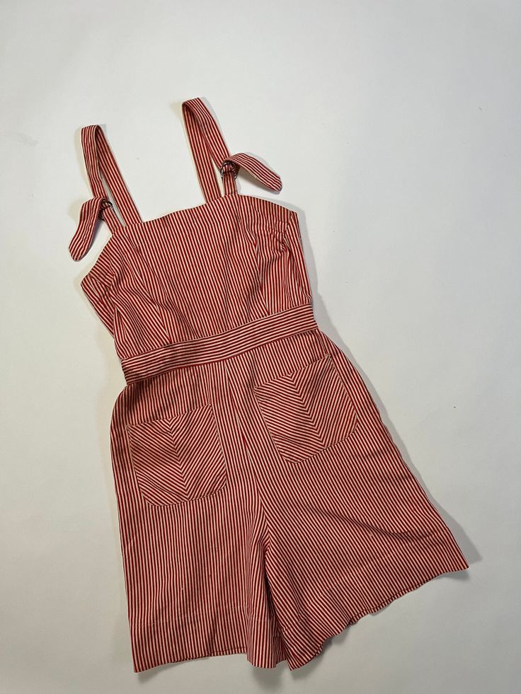 "Vintage 1940's red & white striped overall shorts. Medium-weight cotton material. Adjustable shoulder straps. Two front pockets. Buttons down the back with MOP buttons. This piece appears to be homemade as there's a lot of hand sewn details. There are a few dark colored stains on front and back, with the most major at the waist area-see photo, but this item is still in good wearable condition. Please see all photos & measurements, item is being sold as-is. . M E A S U R E M E N T S.  measured l Vintage Cotton Summer Overalls, Red Cotton Summer Jumpsuits And Rompers, Vintage Sleeveless Overalls For Summer, Striped Overalls With Pockets For Summer, Red Cotton Overalls For Summer, Red Retro Jumpsuits And Rompers For Summer, Red Cotton Summer Overalls, Red Summer Overalls With Pockets, 1940s Overalls