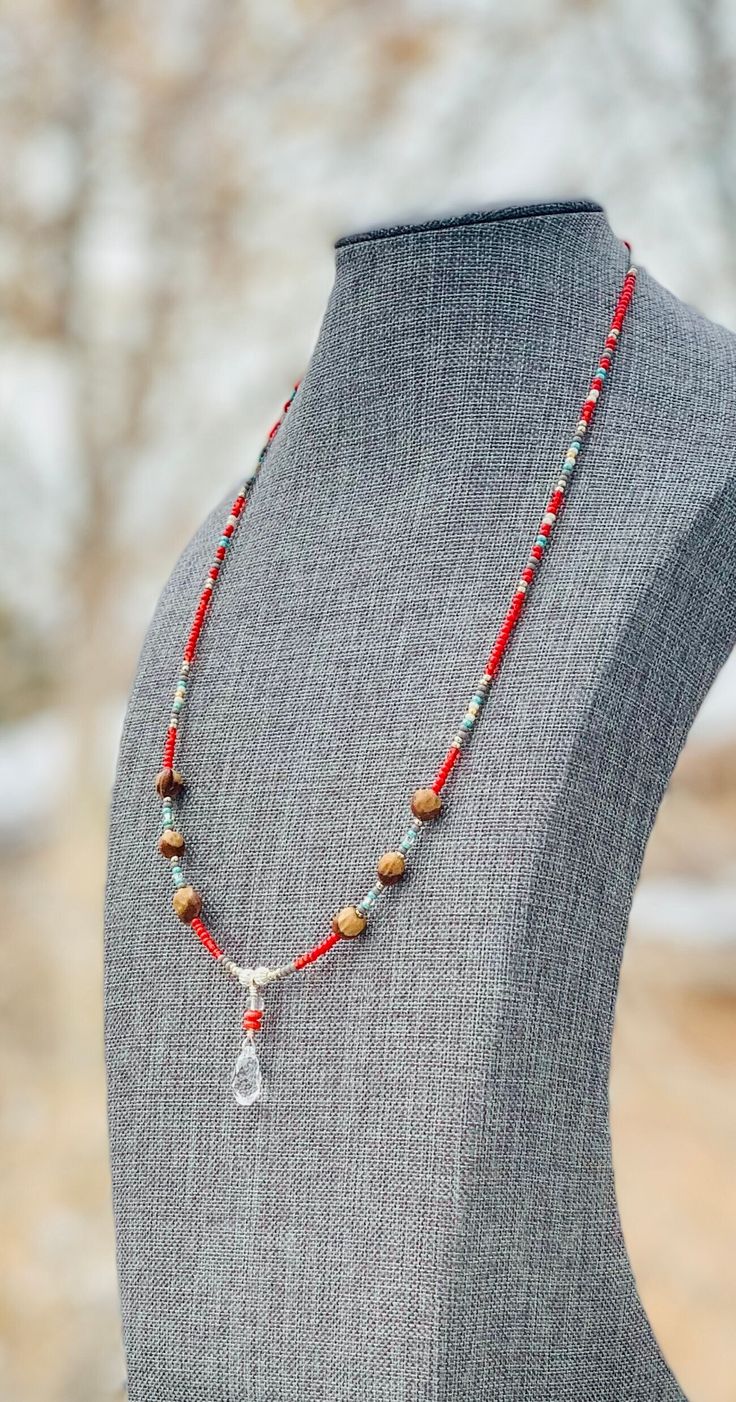 Authentic Native American, handmade, Cedar Juniper Berry seed and Crystal pendant necklace. Cedar beads, colorful glass seed beads, round silver beads and a charm are strung with jewelry wire and closed with lobster claw clasp. Navajo legend says Cedar beads, also known as "Ghost Beads," will keep evil spirits and bad dreams away.  For example, it is customary for Navajo mothers to place strung cedar beads on/near their traditional cradle boards used by their infants.  By season, Navajo and Ute Indians harvest cedar seeds in the southwestern U.S.A. which is a long and arduous process.  The season's yield depends on the amount of rainfall received during the year.  The Indians carefully select the seeds which have had their core previously eaten by ants which is evidenced by a single hole i Spiritual Beaded Necklaces With Dangling Beads As Gift, Lariat Beaded Necklaces With Dangling Beads For Gifts, Gift Lariat Beaded Necklaces With Dangling Beads, Silver Heishi Beads Bohemian Necklace, Silver Bohemian Heishi Beaded Necklaces, Silver Bohemian Heishi Beaded Necklace, Festival Jewelry With 108 Heishi Beads, Spiritual Beaded Lariat Necklace, Spiritual Teardrop Beaded Necklaces For Jewelry Making