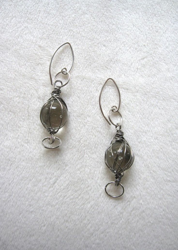 Vintage clear marbles are wrapped with stainless steel wire. Fun earrings that go with everything! 1 1/2"drop. Sterling silver ear wires. Silver Dangle Wire Earrings, Nickel-free Dangle Wrap Earrings In Silver Plated Wire, Nickel-free Silver Plated Dangle Wrap Earrings, Dangle Wrap Earrings With Silver Plated Wire, Silver-plated Dangle Wrap Earrings With Ear Wire, Clear Wire Wrapped Glass Jewelry, Wire Wrapped Clear Glass Jewelry, Clear Glass Wire Wrapped Jewelry, Silver Wire Dangle Wrap Earrings