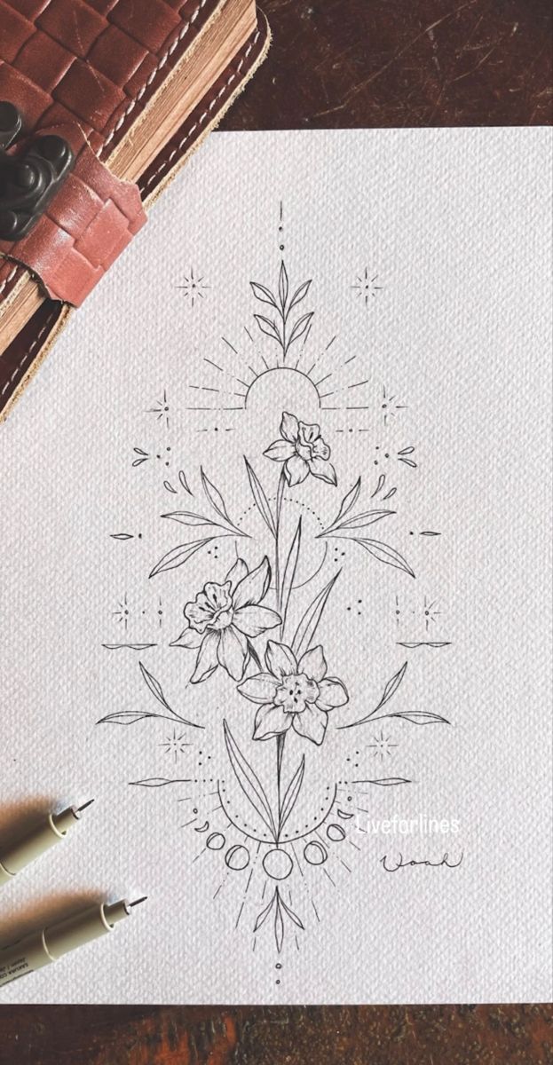 a drawing of flowers on paper next to some pens