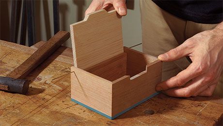 a man is working on a wooden box