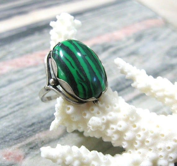 Vintage fashion jewelry, Malachite imitation woman's ring in size 9.Only 1 item available, not adjustable and not resizeable. Very good condition.Size: 9 ( US and Canada ), R 3/4 ( UK and Australia ), 19 ( Europe ).Stone: stripy green MAlachite imitation ( AKA pressed stone or reconstituted malachite )The stone is oval shape, measuring 14X10 mm and standing 7 mm tall over the finger surface.Material: Silver plated brass.This is a high quality ring in electric silver plate with 980 silver that la Adjustable Turquoise Gemstone Ring, Adjustable Green Turquoise Gemstone Ring, Unique Green Round Jewelry, Green Emerald Cabochon Rings, Unique Green Emerald Ring For Formal Occasions, Green Turquoise Ring For Jewelry Making, Adjustable Green Malachite Jewelry, Green Malachite Rings As A Gift, Unique Green Ring Jewelry