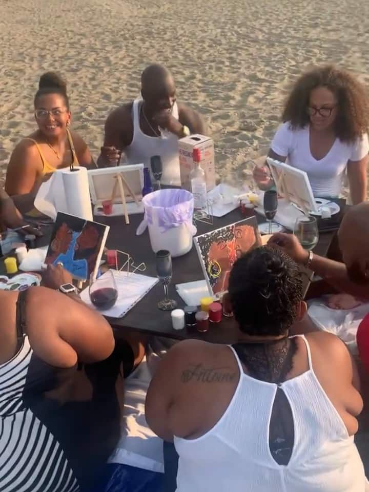 a group of people sitting at a table on the beach