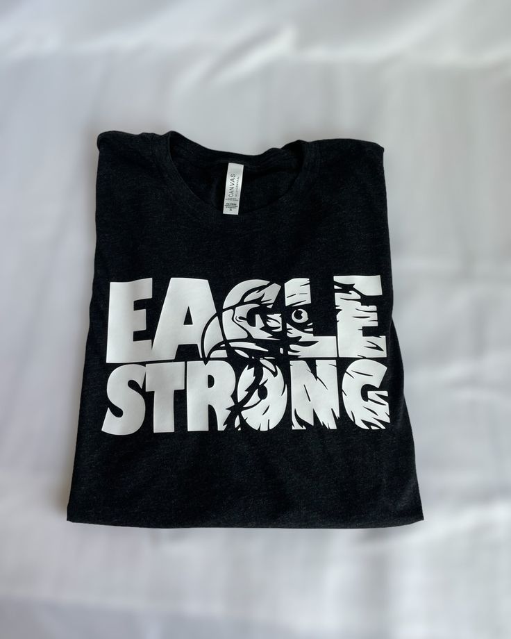 Show off your eagle pride with our Eagle Strong T-shirt, perfect for any die-hard Avon fan. Made of a soft blended fabric, you'll feel like an eagle soaring through the sky when you wear it! Looking for something extra cozy? We also have hoodies and crewneck sweatshirts--just shoot us a message! Eagles Shirt Ideas, Eagles School Shirt, Eagles Spirit Wear, Homecoming Shirts, Friday Night Lights Shirt, Eagles T Shirt, Eagle Soaring, Shirt Crafts, Booster Club