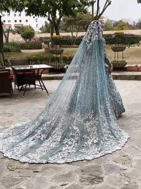 a woman wearing a blue wedding gown with long veil