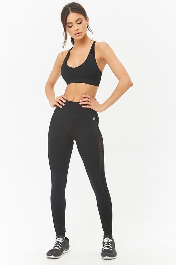 a woman in black sports bra top and leggings with her hands on her hips