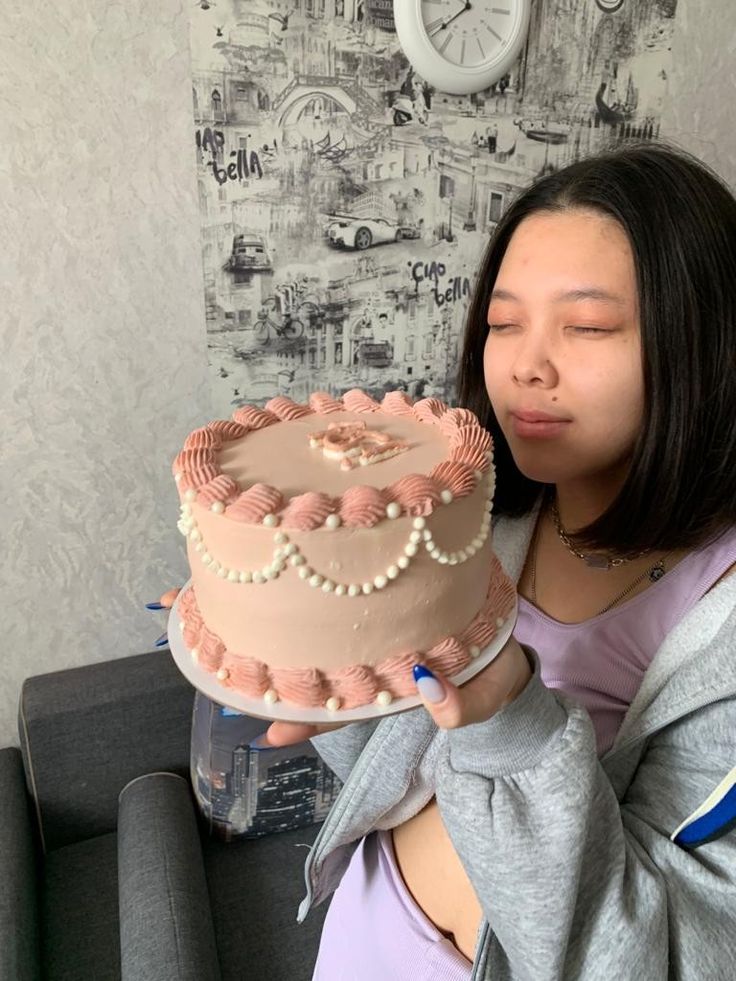 a woman blowing out the candles on a cake that is sitting on a table next to a clock