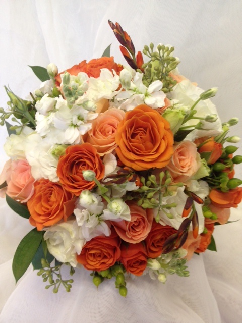 an orange and white bridal bouquet is on display