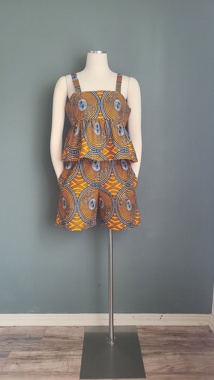 This African print cotton set features a sleeveless top and paper bag waist shorts with side pockets.  Fit: Regular Details: thick straps, empire waistline, shorts with inseam side pockets, elasticated waistband Garments Measurements: Top: Bust: Bust 36 in                    Waist: Free                     Hips: Free                                       Full Length: 20 in Shorts: Waist: 26 in                Hips: 40 in                Full Length: 19 in Fits:  Medium  Bust: 34-36 in /  Waist: 26