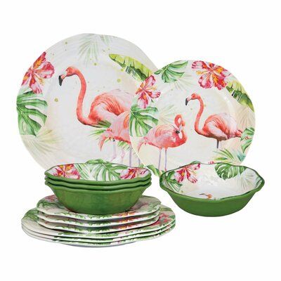 a set of flamingo dinnerware with green rims