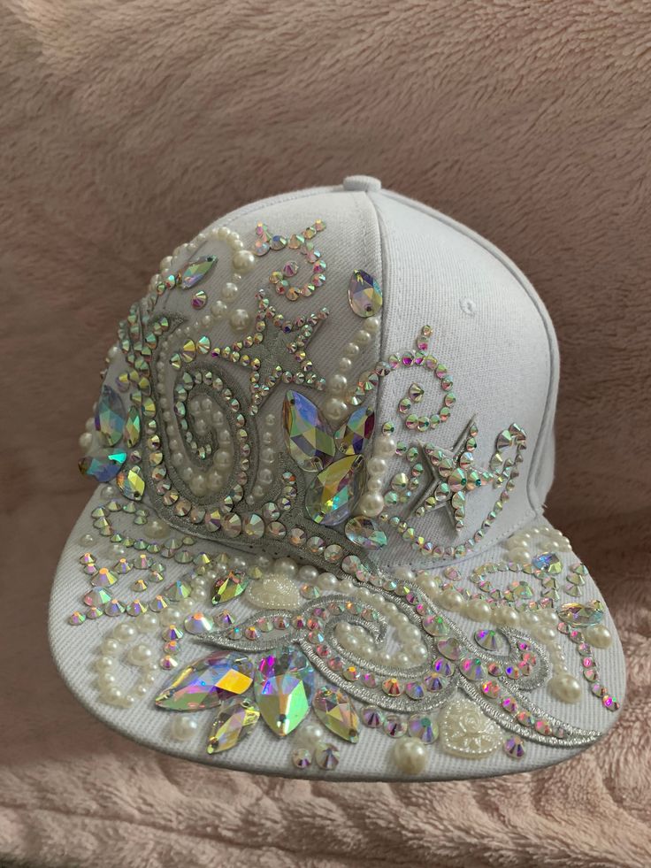 White and silver diamanté crystal festival hat Cap style, size adjustable   Festival hat  Great for weddings or hen dos or just for a fabulous diva !! Encrusted in diamanté's and pearls with appliqué lace and badges  Hand embellished using high quality crystal AB diamanté's and jewel stones.  Please contact me to discuss personalised hats at your request xx White Snapback Party Hat, White Tall Crown Hat With Adjustable Fit, White Snapback Hat For Party, White Adjustable Hat With Tall Crown, White Adjustable Tall Crown Hat, Festival Hats With Rhinestones And High Crown, Festival Hat With Rhinestones And High Crown, White Adjustable Baseball Cap For Party, Adjustable White Baseball Cap For Festivals