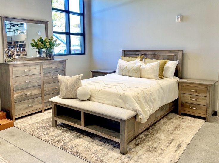 a bedroom with a bed, dressers and mirror in it's center area