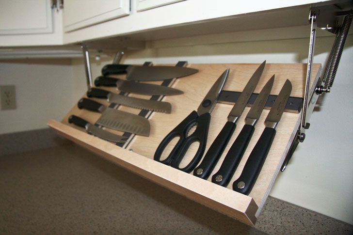 knives are sitting on a cutting board in the kitchen counter top drawer, which is open to reveal several different types of knifes