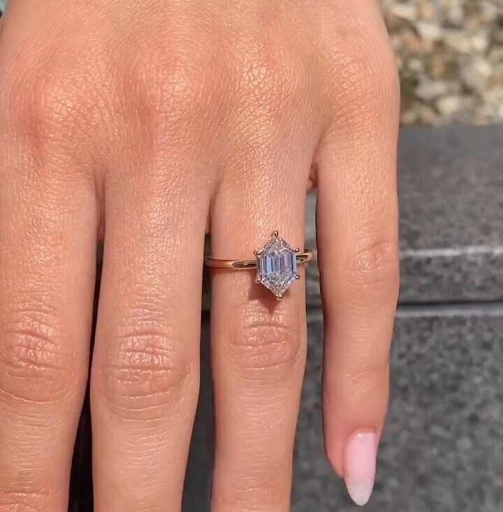 a woman's hand with a ring on it and an engagement band around her finger