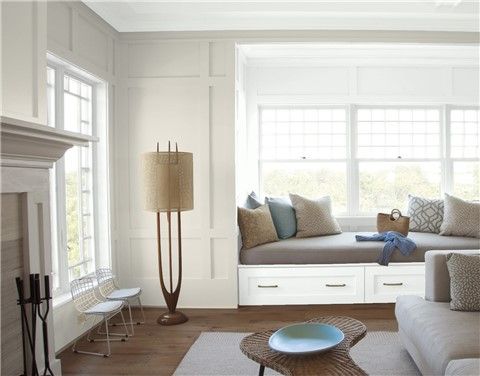 a living room filled with furniture and a fire place next to a white fireplace mantel