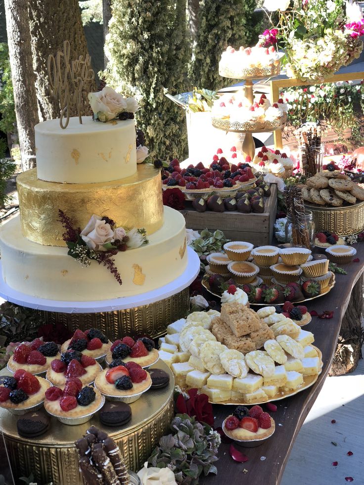 a table topped with lots of cakes and desserts