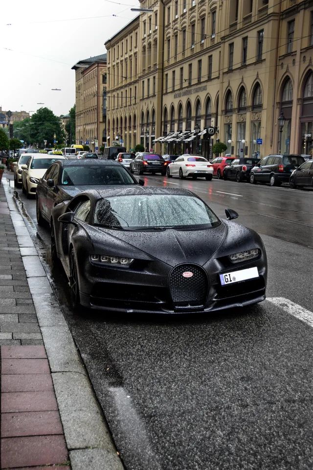 a black bugatti is parked on the side of the road