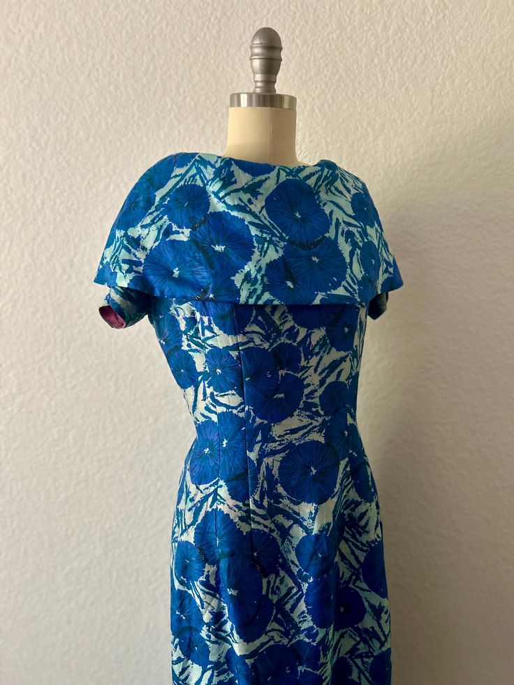 1950s vintage Blue Peony Silk Cocktail dress Shawl Collar silk dress with Cap sleeves Elegant Fit  Metal zipper in back Material:  100% silk  Size:  M Bust:  36" Waist:  28" Hips:  36" Length:  39" (back to hem) Condition:  Good vintage condition; slight fraying of silk around armholes & high stress seam areas Elegant Blue Vintage Dress For Evening, Elegant Blue Vintage Evening Dress, Retro Blue Dresses For Vintage Events, Retro Blue Dress For Vintage Events, Vintage Blue A-line Dress, Silk Blue Dress For Garden Party, Blue Fitted Vintage Dress, Blue Silk Dress For Garden Party, 1950s Style Blue Wedding Dress